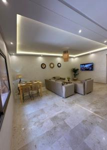 Brand New Modern 2 BR Apartment with Swimming Pool, Netflix & IPTV في مراكش: غرفة معيشة مع أريكة وطاولة
