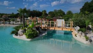 a bridge over the water at a resort at Villa Chicca in Neviano degli Arduini