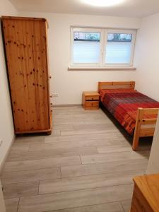 1 dormitorio con cama, ventana y puerta en Fewo Halbe Tanne, en Schonach