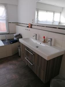 baño con lavabo blanco y ventana en Fewo Halbe Tanne, en Schonach