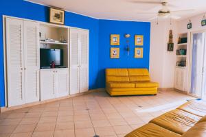 sala de estar con paredes azules y silla amarilla en Hermoso Departamento Casa Blanca remodelado 2 Habitaciones Wi-Fi Netflix, en Same