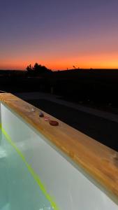 a view of the sunset from the edge of a swimming pool at Viento Sur Pichilemu Tiny House con Mini Parrilla y opción de Hot Tub in Pichilemu