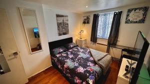 niewielka sypialnia z łóżkiem i oknem w obiekcie Comfy apartment w Londynie