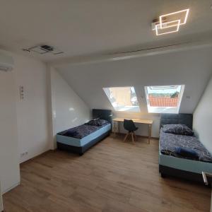 Zimmer mit 2 Betten und einem Schreibtisch. in der Unterkunft City Apartments Offenbach in Offenbach