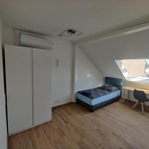 Cette chambre comprend un lit, un bureau et une fenêtre. dans l'établissement City Apartments Offenbach, à Offenbach-sur-le-Main