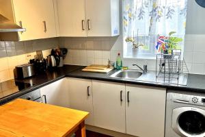 cocina con fregadero y lavavajillas en Comfy apartment, en Londres