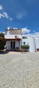 une maison blanche avec un cimetière devant elle dans l'établissement Villa Nisi, à Agia Galini