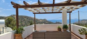 a balcony with a pergola with plants on it at Villa Nisi in Agia Galini