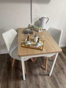 1 Zimmer Appartement in Bad Rothenfelde في باد روتنفيلد: طاولة خشبية مع كرسيين بيض وطاولة مع مشروب