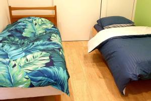- une chambre avec un lit et une couette bleue dans l'établissement Cosy apartment Paris + Disneyland, à Limeil-Brévannes