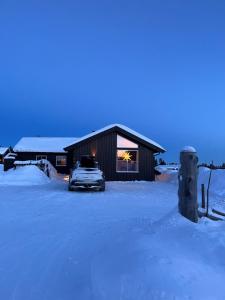 a car parked in front of a building in the snow at Beautiful cabin close to activities in Trysil, Trysilfjellet, with Sauna, 4 Bedrooms, 2 bathrooms and Wifi in Trysil