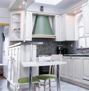 a kitchen with white cabinets and a green ceiling at Kouros Cozy Home in Orestiada