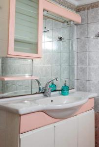 a bathroom with a sink and a mirror at Kouros Cozy Home in Orestiada