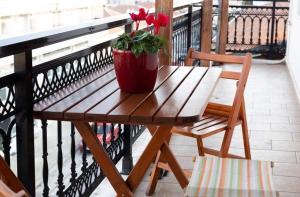 Orestiada的住宿－Kouros Cozy Home，阳台上的木桌和盆栽植物