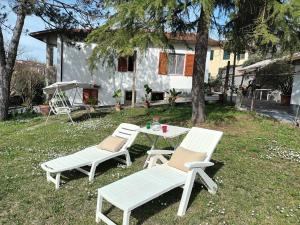 twee witte stoelen en een tafel voor een huis bij La casa del ponte romano in Pogi
