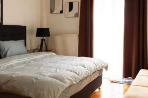 Orestiada的住宿－Kouros Cozy Home，一间卧室配有一张床、一张沙发和一个窗口