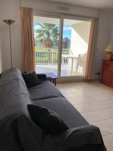 een bed in een slaapkamer met uitzicht op een patio bij APPART - T3 - 6 PERSONNES – GOLF CAP D’AGDE in Cap d'Agde