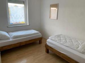 Duas camas num quarto com uma janela em Monteur- und Ferienhaus Weitblick Schonungen em Schonungen
