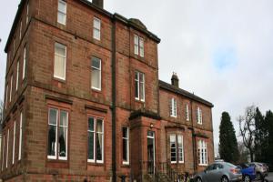 a red brick building with a man on top of it at OYO Kirkconnel Hall Hotel in Ecclefechan