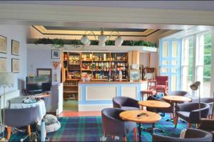 a restaurant with tables and chairs and a bar at OYO Kirkconnel Hall Hotel in Ecclefechan