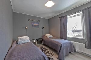 2 camas en una habitación con ventana en Riekko Mökki en Kilpisjärvi