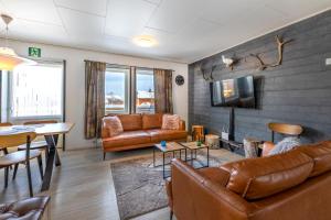 a living room with leather furniture and a tv at Riekko Mökki in Kilpisjärvi