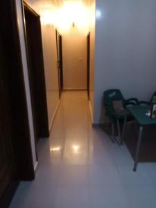 un corridoio con luce, porta e sedie di Residence Fadi à Diamniadio a Dakar