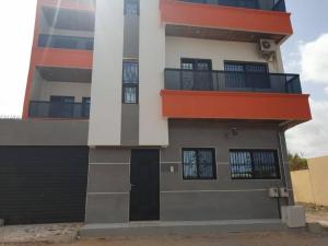 a building with a black door and a balcony at Residence Fadi à Diamniadio in Dakar