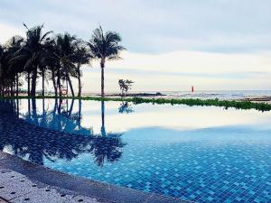 濠莊的住宿－Hồ Tràm Wonderland - Mocha Villa 2 Phòng Ngủ，毗邻大海的棕榈树游泳池