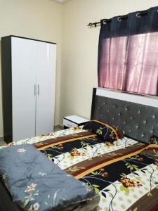 una camera con letto con testata nera di Residence Fadi à Diamniadio a Dakar