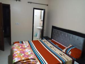 a bedroom with a bed with an orange bedspread and a bed frame at Residence Fadi à Diamniadio in Dakar