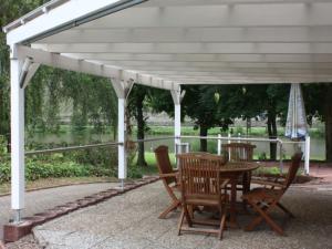 a white pergola with a wooden table and chairs at Apartment in Trittenheim with Terrace and Garden in Trittenheim