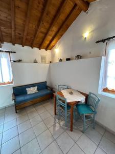 a room with a table and chairs and a blue couch at Amalia beach apartment in Kokkari +15 photos
