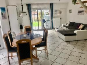 uma sala de estar com uma mesa e um sofá em Huus Wattenmeer in Neßmersiel an der Nordsee em Dornum