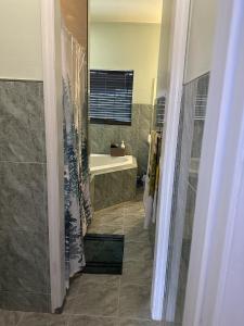 a bathroom with a shower and a sink and a tub at Quiet Haven in Freeport