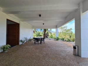 un patio avec une table et des chaises dans un bâtiment dans l'établissement Azure Ocean View Villa, à Puerto Galera