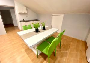 a kitchen with a white table and green chairs at Apartments Suzi Crikvenica in Crikvenica