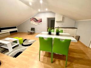 a living room with a table and green chairs at Apartments Suzi Crikvenica in Crikvenica