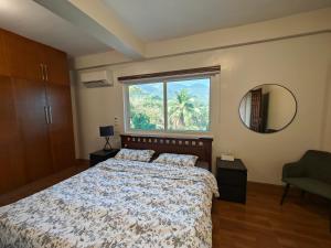 una camera da letto con un letto e una grande finestra di Azure Ocean View Villa a Puerto Galera