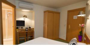 a room with a bed and a dining room with a television at Hotel Zaragoza Plaza in Donostia-San Sebastián