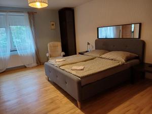 sypialnia z dużym łóżkiem i krzesłem w obiekcie Apartmán Dvořák 194 pod Svatou horou w Przybramiu