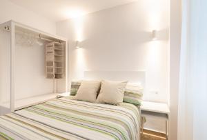 1 dormitorio con 1 cama con manta a rayas en Nordik Apartments Urban - Perchel "Skogar", en Málaga