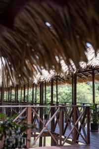 a straw roofed restaurant with a field of grass at Manati Lodge in Manacapuru