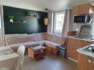 een woonkamer met een bank en een tafel bij Camping du Bois Dormant in Saint-Jean-de-Monts