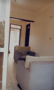 uma sala de estar com dois sofás e uma janela em Sweet Home Buziga em Gaba