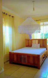 um quarto com uma cama com um lustre por cima em Sweet Home Buziga em Gaba
