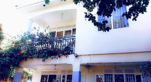um edifício branco com uma varanda e flores sobre ele em Sweet Home Buziga em Gaba