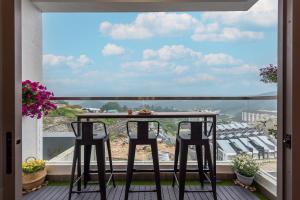 d'un balcon avec une table et des chaises et une vue. dans l'établissement Serene Modern Family Retreat(2-7 pax)&Sunrise View, à Cameron Highlands