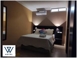 um quarto de hotel com uma cama e um espelho em W Hotel em Pasaje