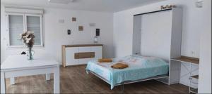 - une chambre avec un lit, une table et un vase de fleurs dans l'établissement Penthouse panoramique avec Jacuzzi, à Ajaccio